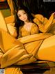 A woman laying on a couch in a yellow dress.