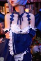 A woman dressed in a blue and white maid outfit.