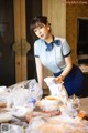 A woman in a blue dress is preparing food on a table.