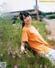 A young woman sitting in a field of flowers.