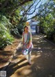 A woman walking down a sidewalk in a park.